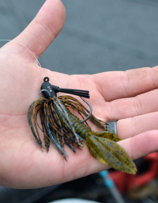 Skirted fishing jig with soft-plastic trailer held in a hand