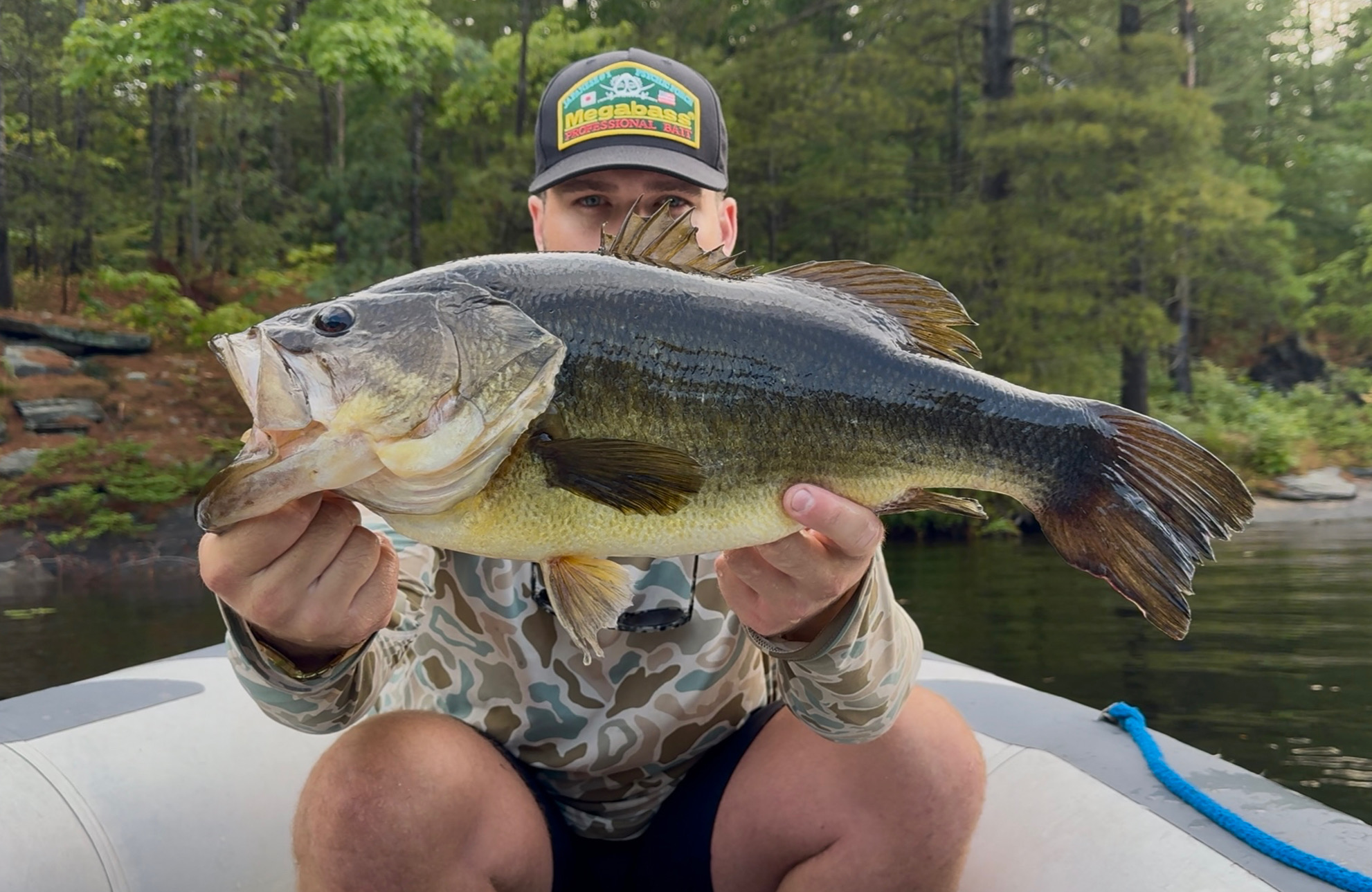 TJ LeClair holding a large largemouth bass on the water