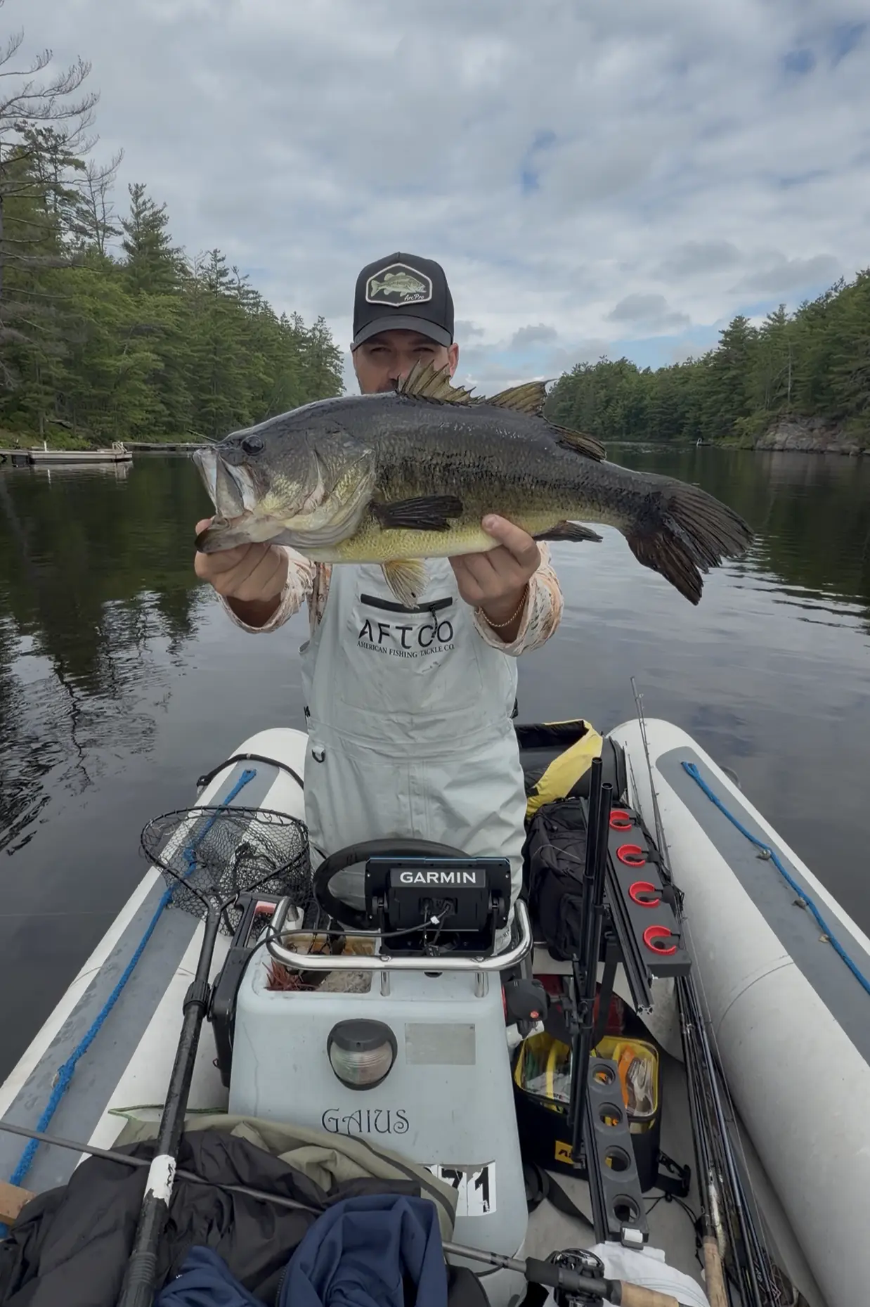 TJ LeClair holding up a big largemouth bass on a Muskoka lake