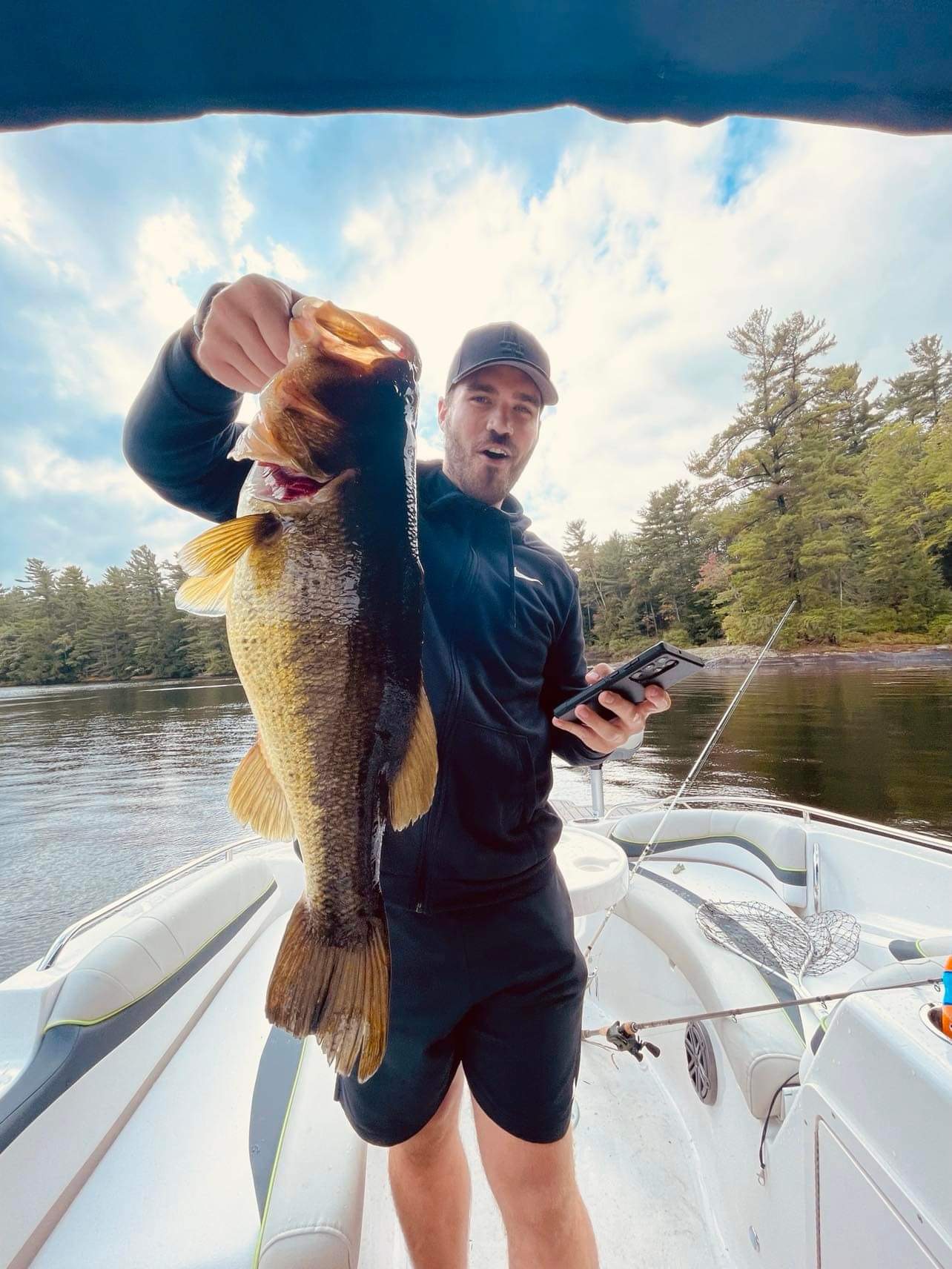 TJ LeClair holding up a big largemouth bass on the boat deck