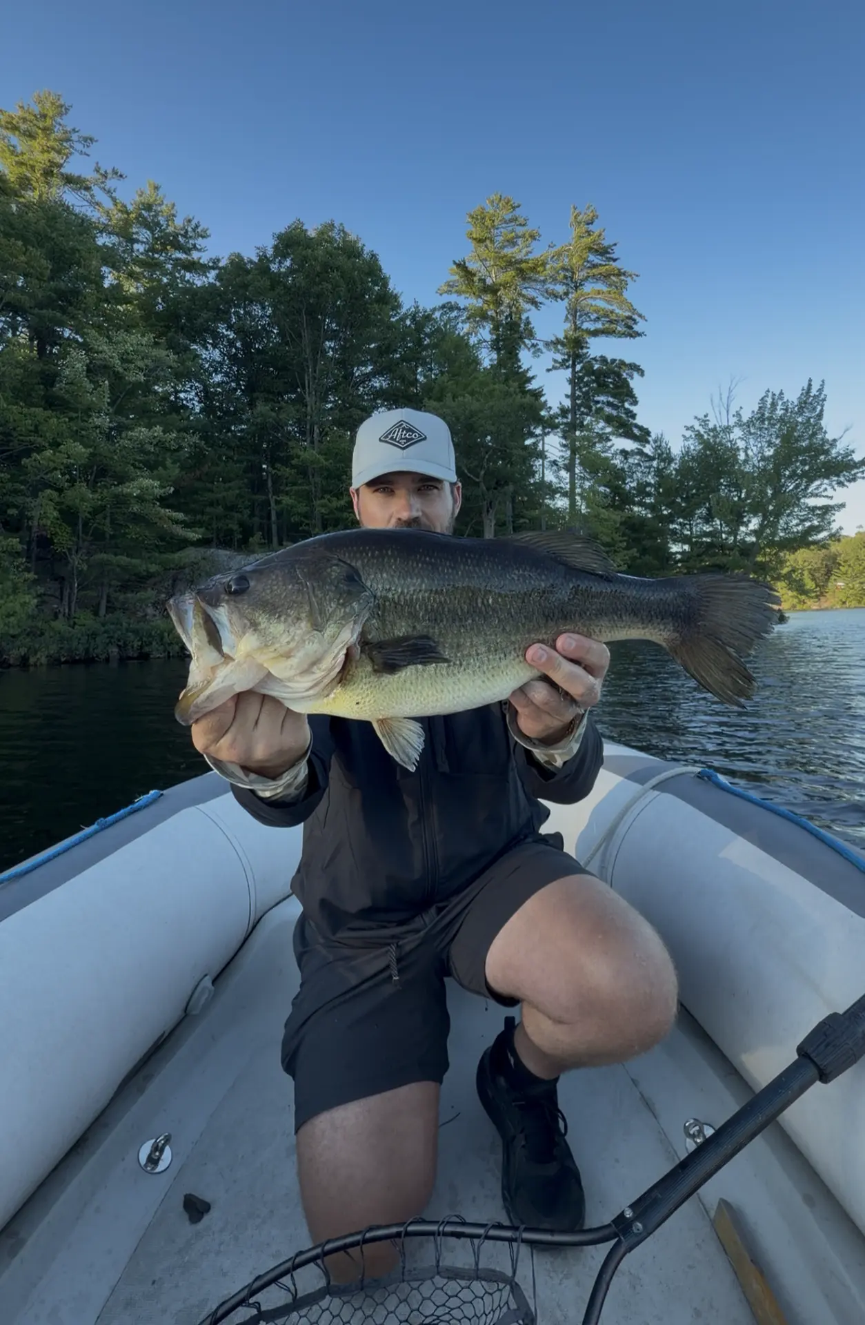 TJ LeClair holding a big largemouth bass at golden hour